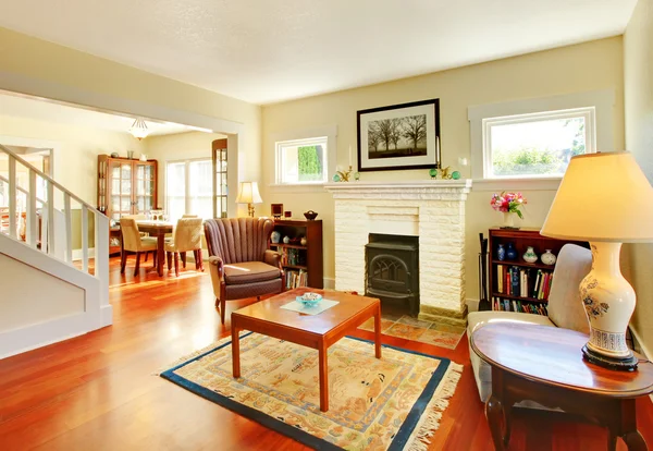 Bela sala de estar ensolarada com lareira e piso de cereja . — Fotografia de Stock