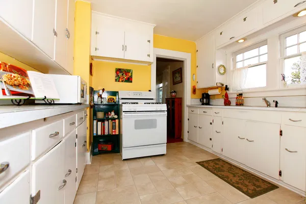 Бело-желтая старая простая кухня . — стоковое фото