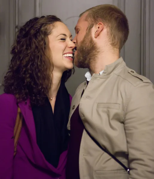 Jovem casal no corredor escuro beijando e rindo . — Fotografia de Stock