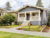 Grey craftsman style house with white porch.