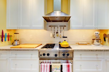 WHite kitchen cabinets with stove and hood. clipart