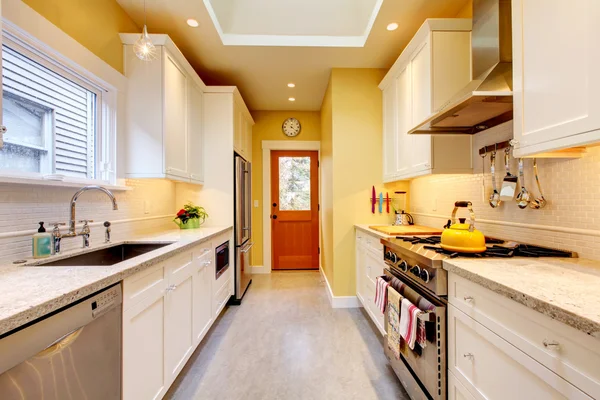 Yellow and white narrow modern kitchen. — Stock Photo, Image