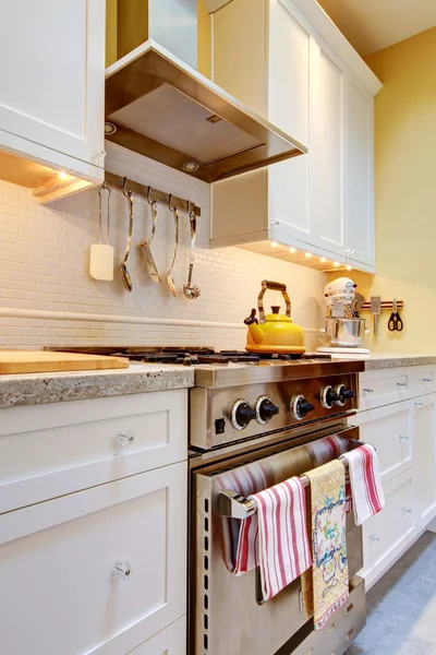 Yellow kitchen with white cabinets and stove. — Stock Photo, Image