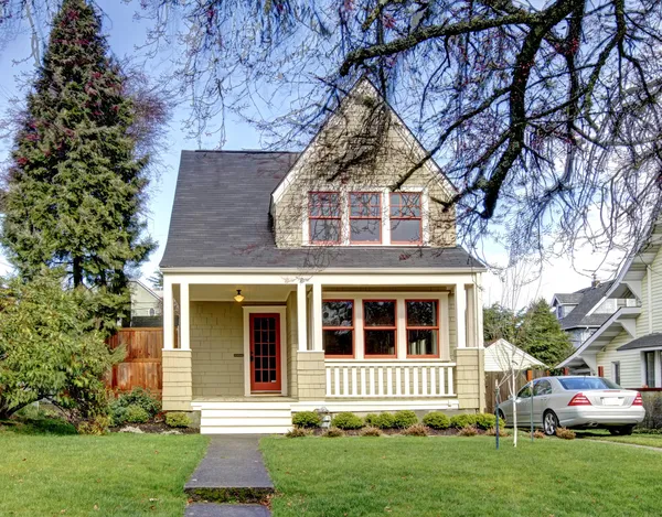 Pequeña casa verde con porche y coche . — Foto de Stock
