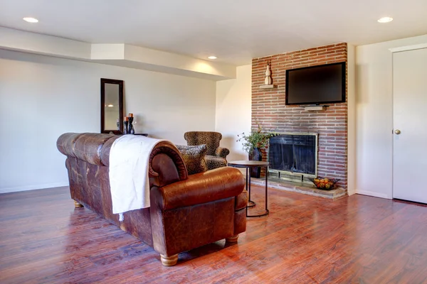 Obývací pokoj s koženou pohovkou a krb. — Stock fotografie
