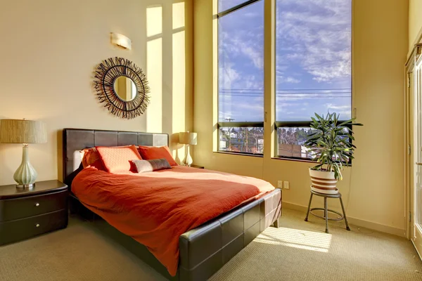 Groot hoog plafond slaapkamer met rode bed. — Stockfoto