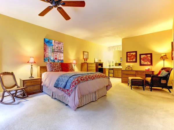 Stora gula sovrum inredning med röd säng. — Stockfoto