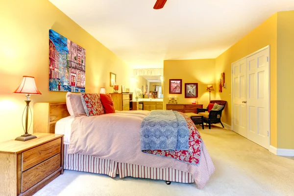 Stora gula sovrum med röd säng. — Stockfoto