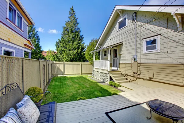 Beautiful spring back yard with fence and house. — Stock Photo, Image