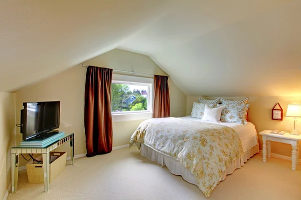 Béžové podkrovní ložnice s tv a bílá postel. — Stock fotografie