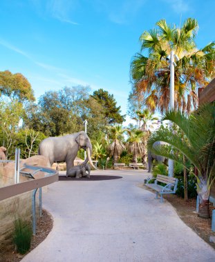 Trail in San Diego zoo with elephant sculpture. clipart