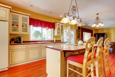 Gold kitchen with white antique cabinets.