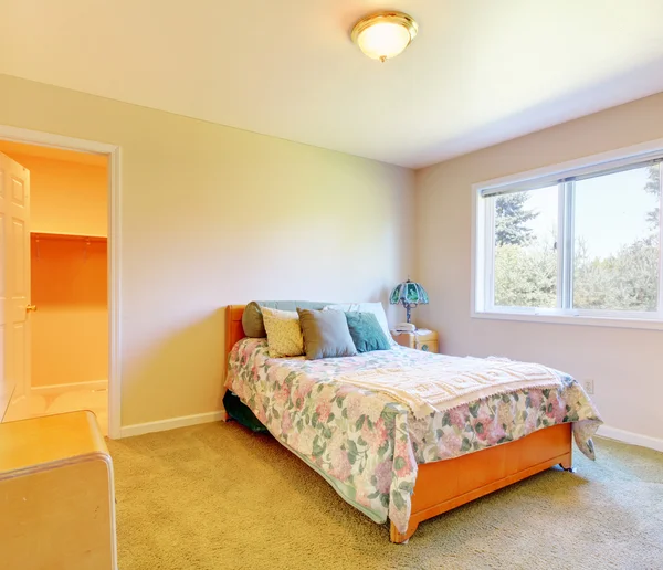 Litet sovrum med enkel säng och beiga väggar. — Stockfoto