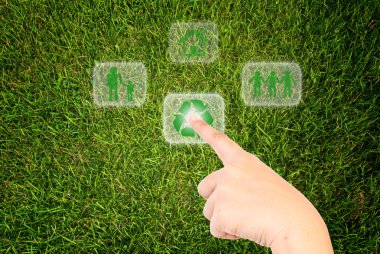 Hand pressing recycle icon on the grass field. clipart