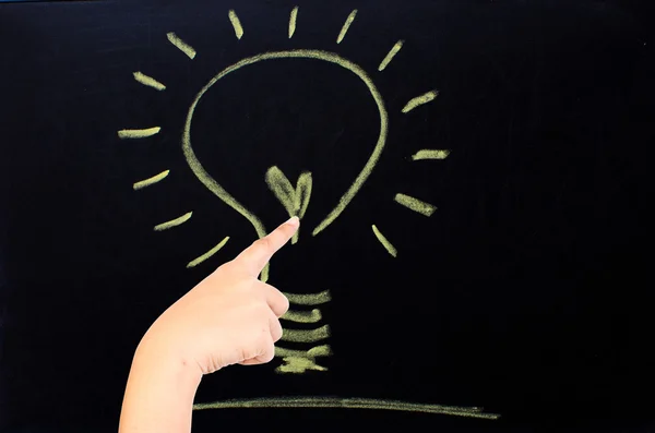 Hand push Light bulb as idea concept on the blackboard. — Stock Photo, Image