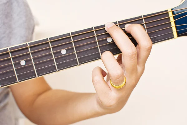 Hand op klassieke gitaar akkoorden te drukken. — Stockfoto