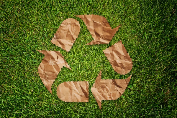 Vintage recycle symbol on the grass field. — Stock Photo, Image