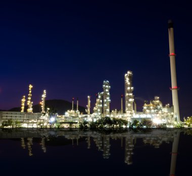 Petrokimya endüstrisi günbatımı koyu mavi gökyüzü üzerinde yansıması.