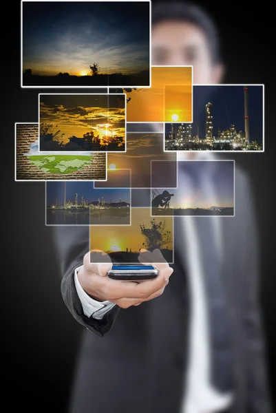 Businessman putting cell phone with images. — Stock Photo, Image