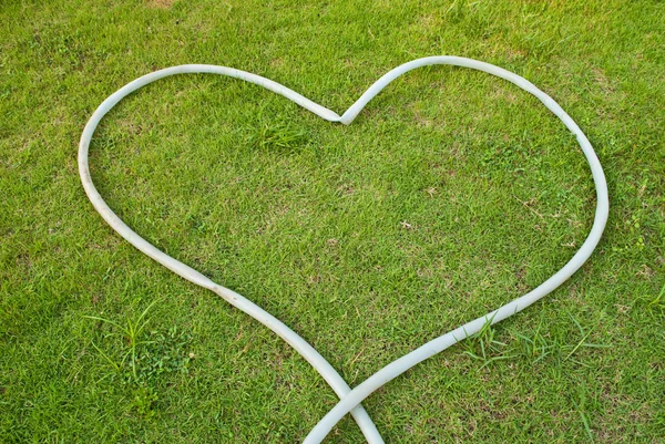 สัญลักษณ์หัวใจบนสนามหญ้าสีเขียว — ภาพถ่ายสต็อก