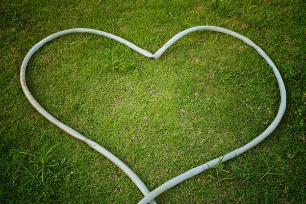 Símbolo de coração no campo de grama verde — Fotografia de Stock