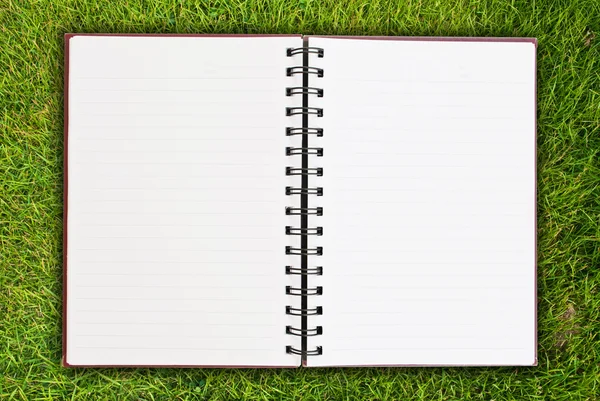 White notebook on grass field texture. — Stock Photo, Image