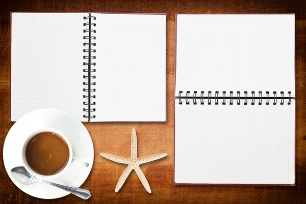 Cuaderno sobre la textura de madera con estrella de mar y taza de café . — Foto de Stock