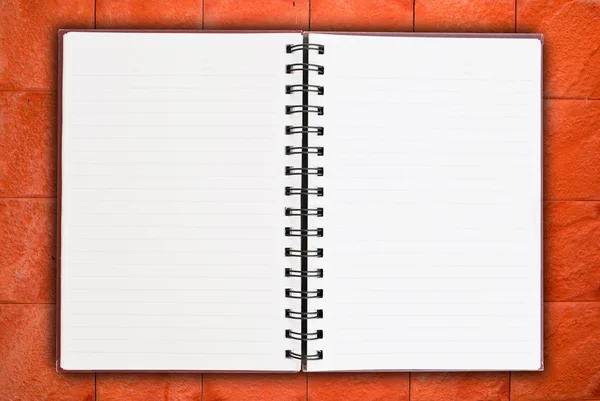A fal textúra háttéren fehér notebook. — Stock Fotó