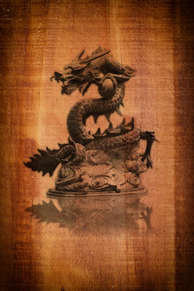 Kinesisk stil dragon staty på trä textur. — Stockfoto