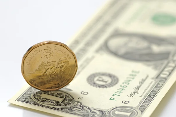 Nám jeden dolar bill vs kanadské jednodolarové mince — Stock fotografie