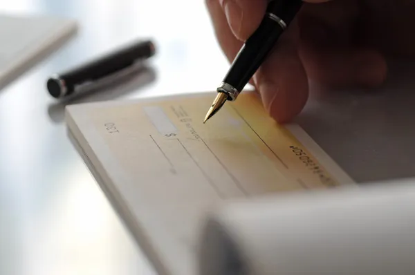 Empresario escribiendo el cheque — Foto de Stock