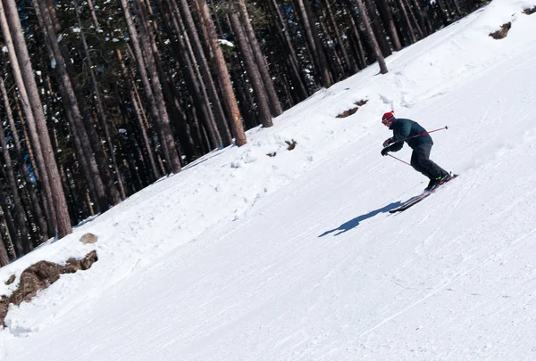 滑雪者从陡峭的斜坡向下雕刻 — 图库照片