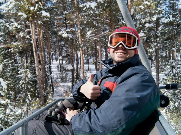 Man skier on chairlift in forest — Stock Photo, Image