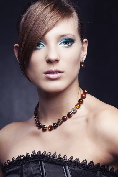 Piękna dziewczyna z doskonałej skóry w czarnej sukni z biżuterią — Zdjęcie stockowe