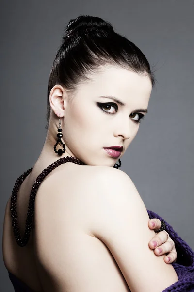 Piękna dziewczyna z doskonałej skóry w czarnej sukni z biżuterią — Zdjęcie stockowe