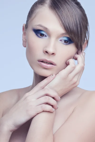 完璧な肌、青い背景に明るいトレンディな化粧と美しい女性 — ストック写真