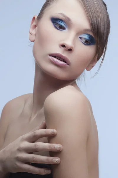 Schöne Frauen mit perfekter Haut, helles, trendiges Make-up auf blauem Hintergrund — Stockfoto