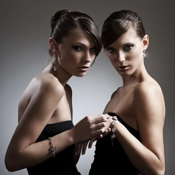 Two beautiful woman in black dress with jewelry — Stock Photo, Image