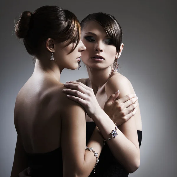 Twee mooie vrouw in zwarte jurk met sieraden — Stockfoto