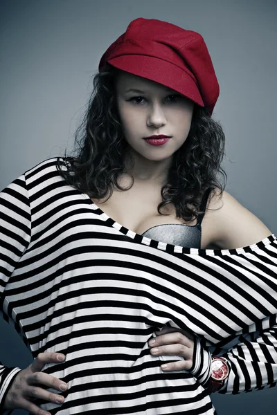 Portret van een mooi meisje met lichte make-up, de klok in een cap — Stockfoto