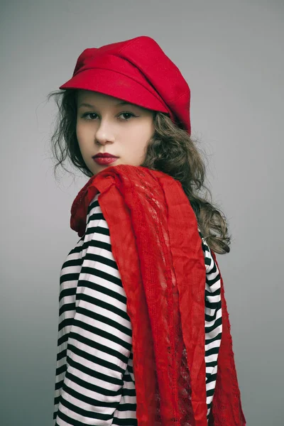 Ritratto di una bella ragazza con trucco luminoso, una sciarpa in un berretto — Foto Stock