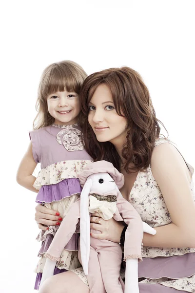 Porträt von Mutter und kleiner Tochter in seinen Armen mit einem Spielzeug — Stockfoto