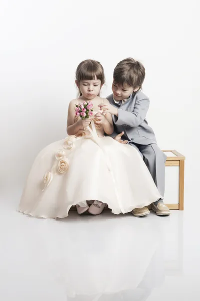 Portret van twee mooie kleine jongens en meisjes in bruiloft jurken — Stockfoto