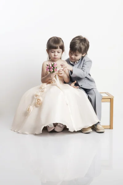 Portrait de deux beaux petits garçons et filles en robes de mariée Photos De Stock Libres De Droits
