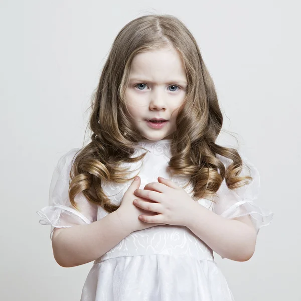 Retrato de uma linda menina em um vestido branco e véu em um fundo branco — Fotografia de Stock