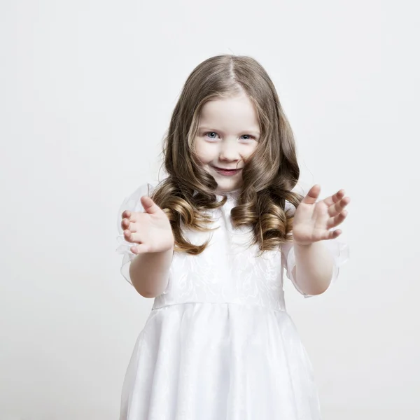 漂亮的小女孩在一个白色的礼服和面纱在白色背景上的肖像 — 图库照片