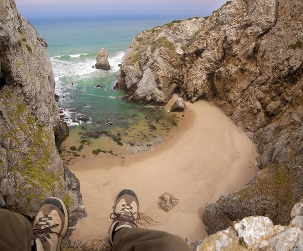 Fötter hänger över stranden klippan — Stockfoto