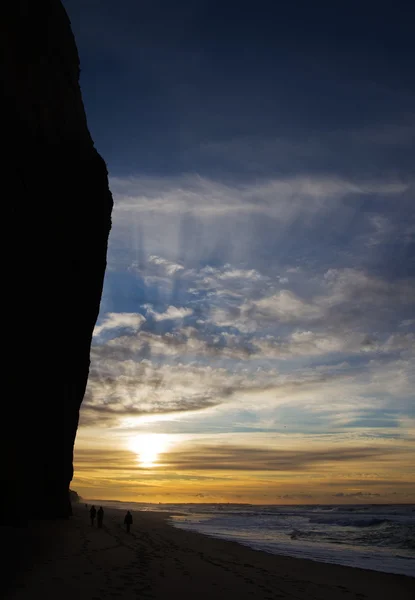 Cliff silhouetted against sunset rays — Stock Photo, Image