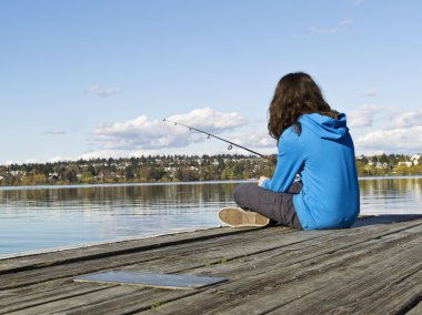 Girl fishing off Dock clipart