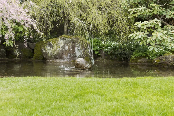 Фонтан воды в саду пруда — стоковое фото